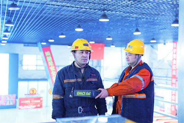 安检人员给入井人员进行验身,防止违禁物品带入井下